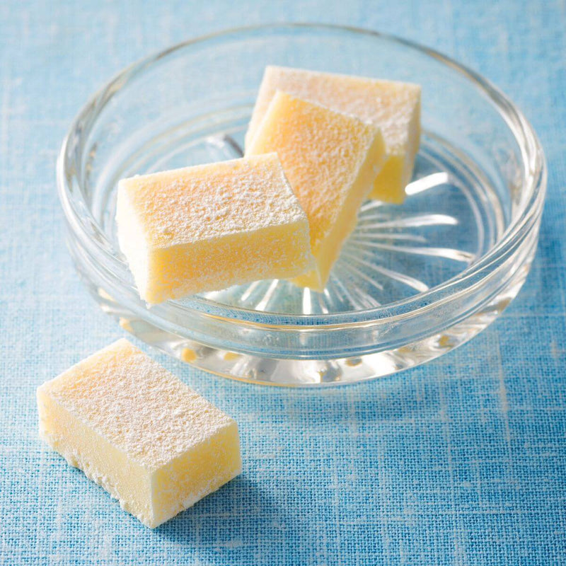 ROYCE' Chocolate - Nama Chocolate White - Image shows white blocks of chocolates on a clear plate. Background is in blue.